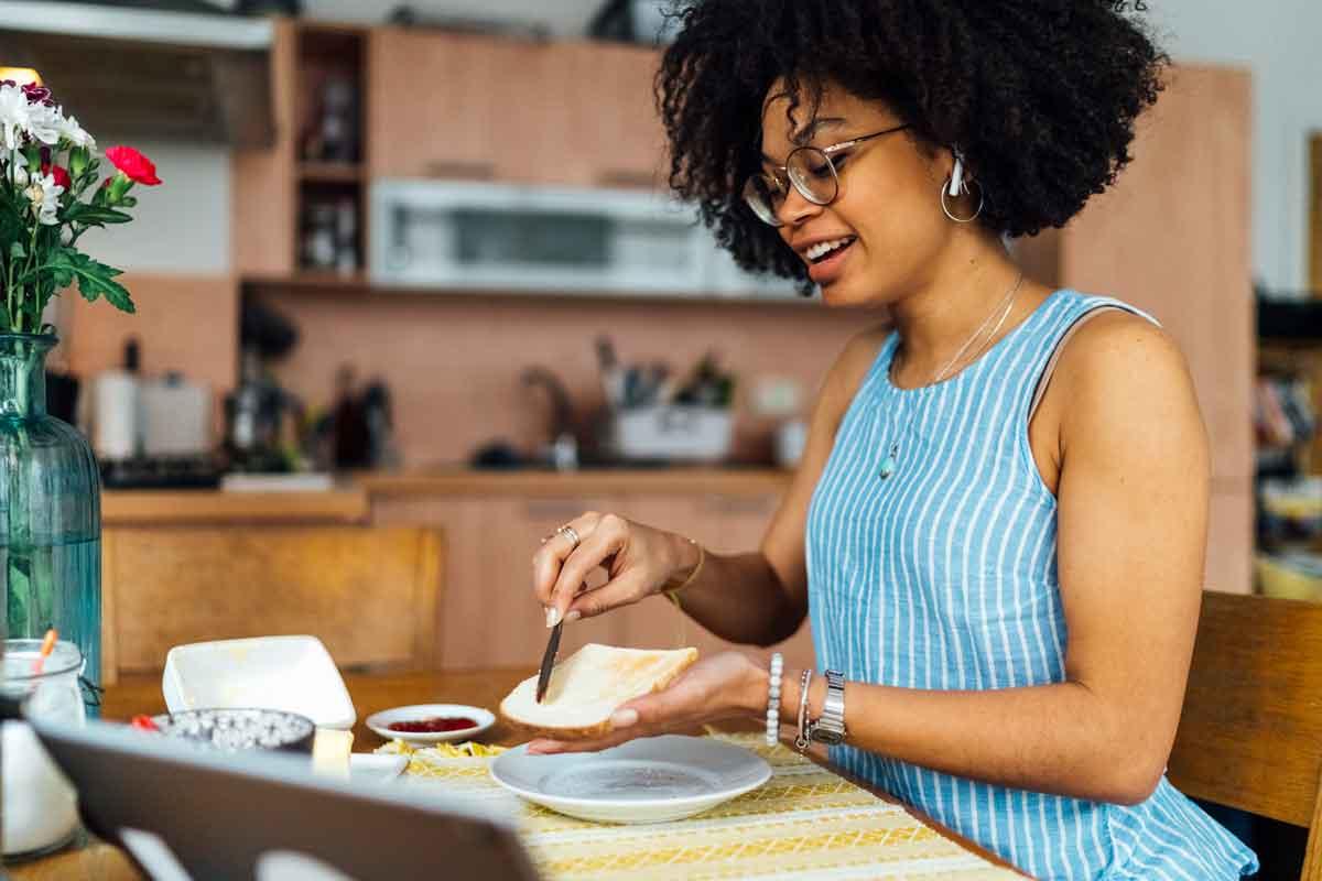 A woman spreading butter on bread