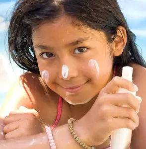 Young girl using sunscreen