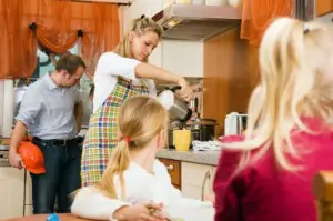 Busy mom pours coffee while children look on