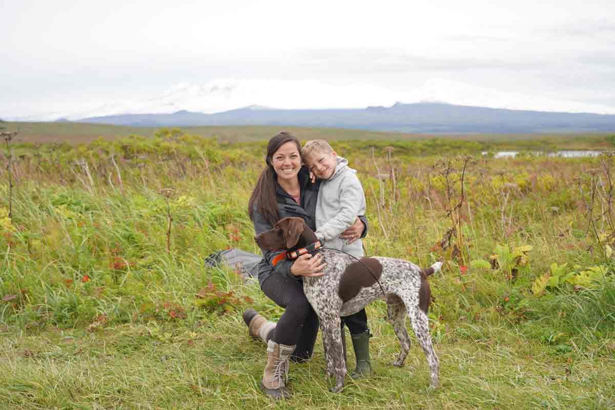 Jenny Foltz, rectal cancer survivor, outside with her son and dog smiling to the camera