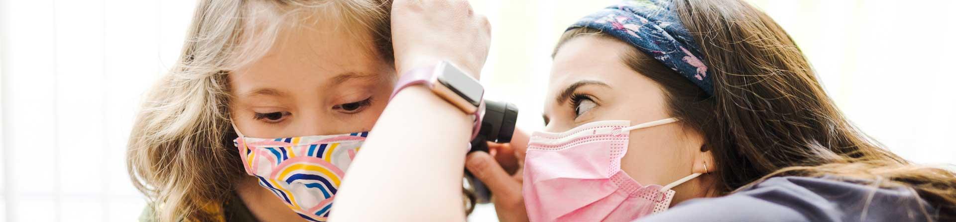 A healthcare provider looking into a girl's ear.