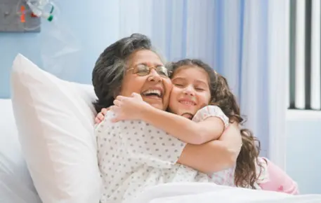 patient embracing family member in hospital bed