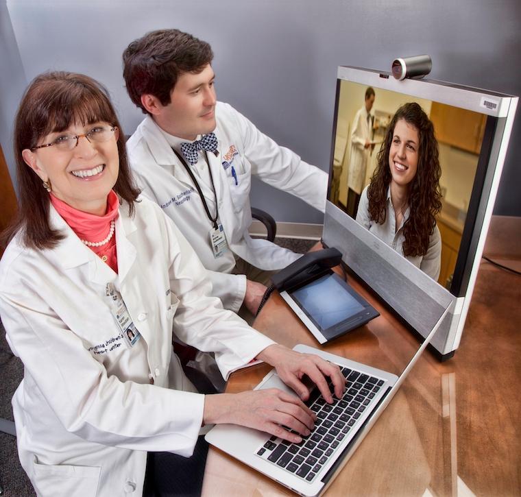 UVA Health's Karen Rheuban, MD, and stroke expert Andrew Southerland, MD, demonstrate telehealth in an image taken before the pandemic.