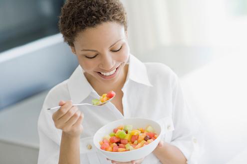 Woman eating fruit salad