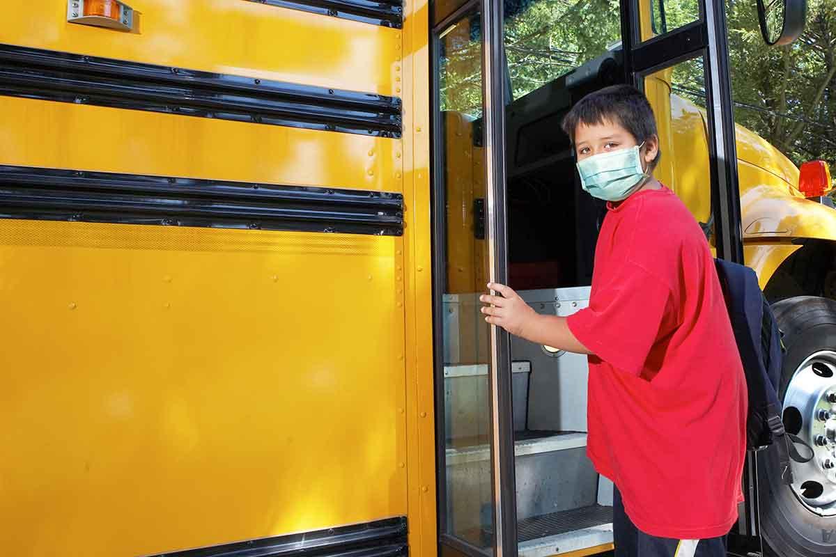 young boy getting onto school bus