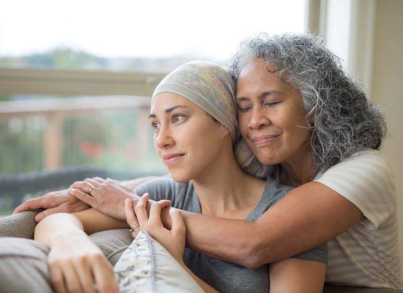 A woman comforts another woman with cancer