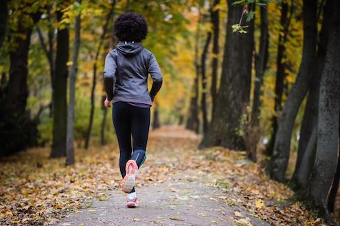 Woman jogging through the woods, how to track your period