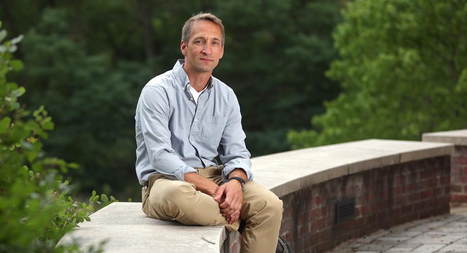  Jochen Zimmer, PhD, sits on a wall on the UVA Grounds