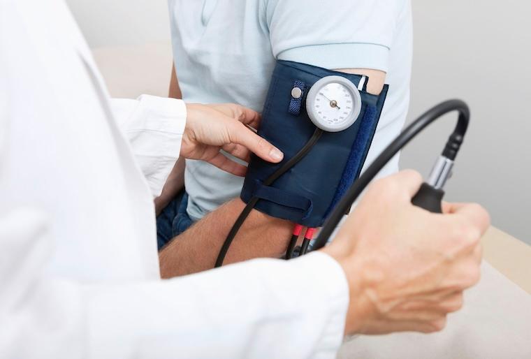 Man has blood pressure taken by doctor using blood pressure cuff