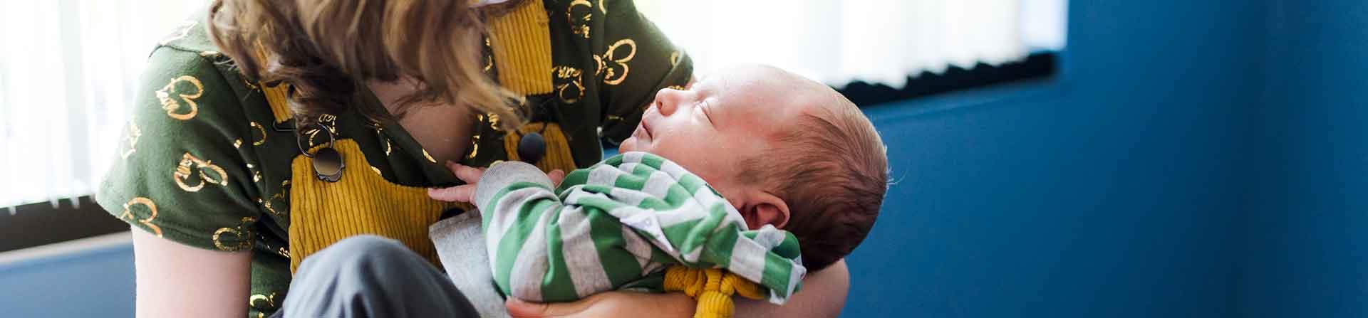 a newborn in sister's arms after infant heart surgery at uva children's