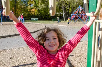 A young girl plays on the monkey bars at recess