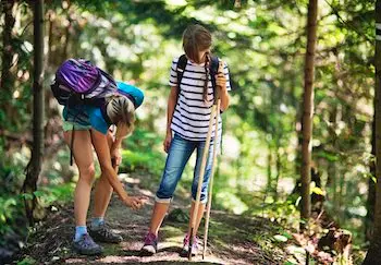 Mother applying tick repellent on daughter to prevent tick-borne illnesses