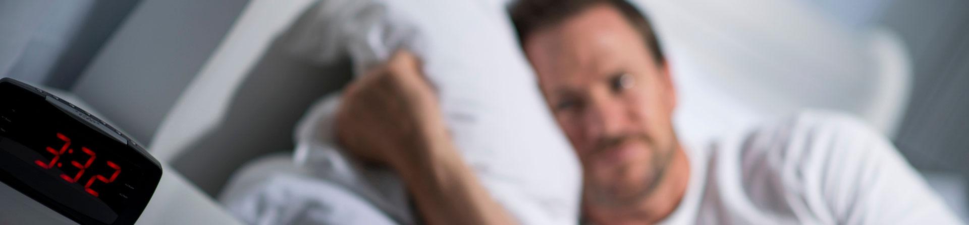 man staring at alarm clock