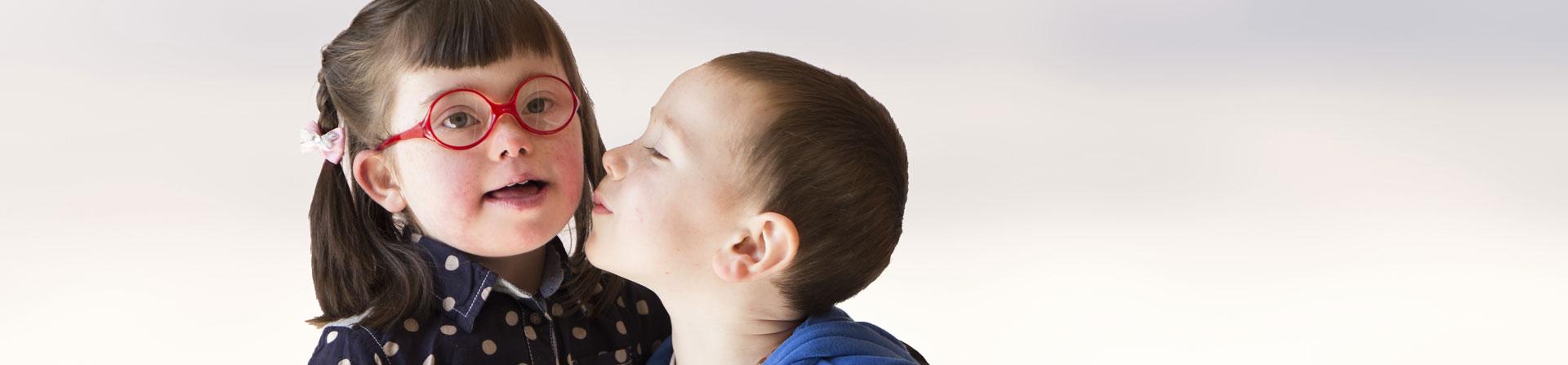 little boy kissing his big sister
