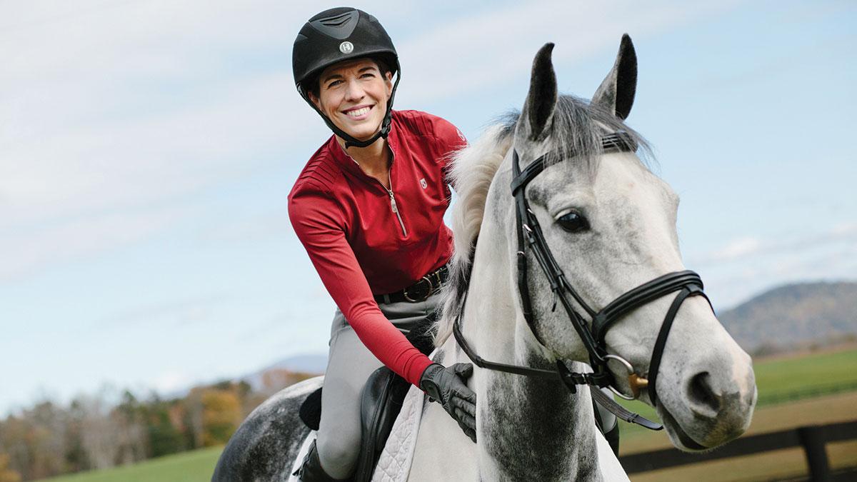 Bajo gives her gray mare, Tika, a gentle pat on the neck.