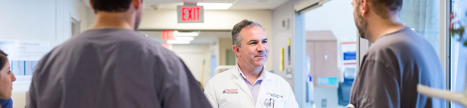 Medical team discusses a patient recovering from brain or spine surgery in the NNICU.